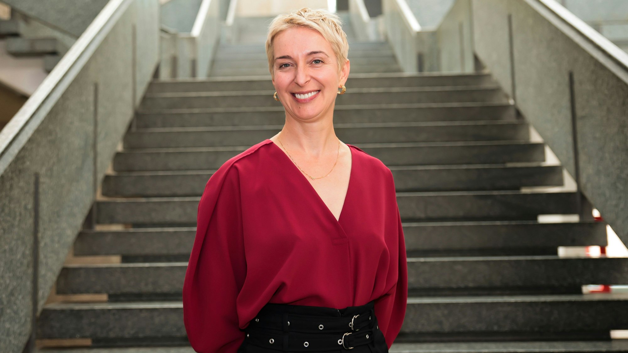 Vorstellung der neuen Indendantin der Philharmonie und der Köln-Musik Gmbh Ewa Bogusz-Moore. Sie trägt eine rote Bluse und lächelt in die Kamera.