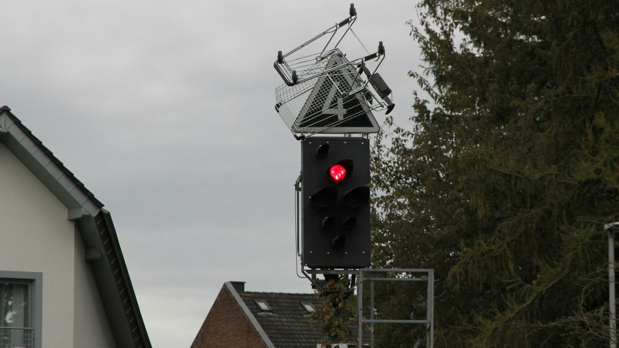 Ein Einkaufswagen auf einem Signalmast an einer Bahnstrecke