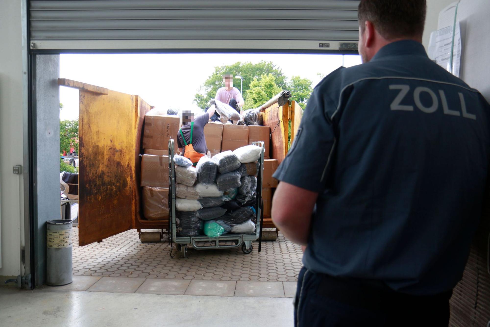 Zwei Personen beladen einen Container mit Kartons und Tüten.