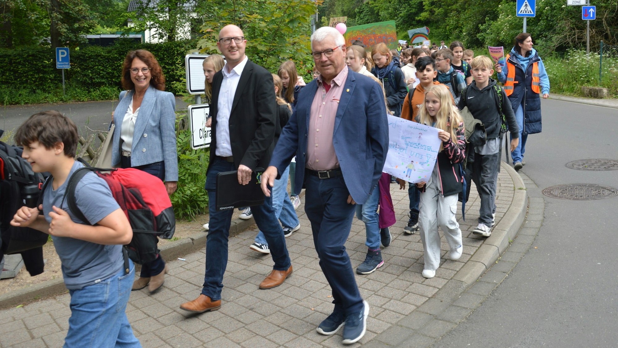 Roswitha Schütt-Gerhards, Ingo Pfennings und Helmut Kauland gehen nebeneinander im Demonstrationszug. Vor und hinter ihnen sind zahlreiche Schüler zu sehen.