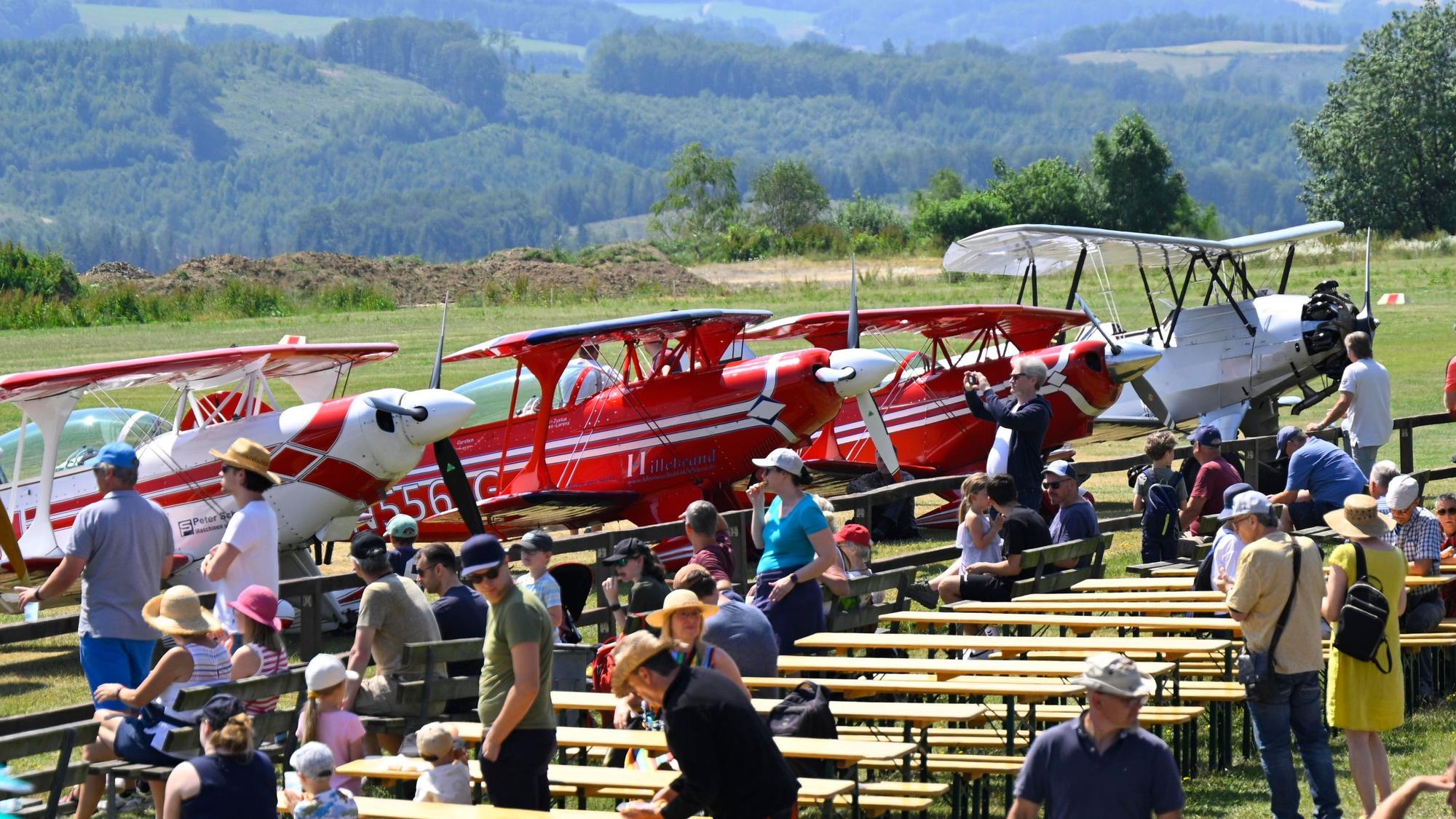 Blick auf das Gelände mit Besuchern und Flugzeugen beim Flugplatzfest in Bergneustadt.