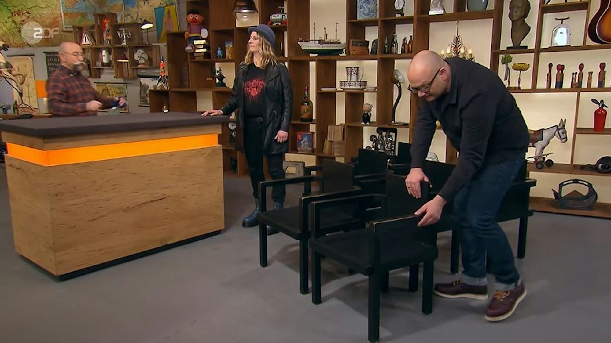 Experte Sven Deutschmanek (r.) inspiziert die Stühle von Eva Wildenhayn aus Bergisch Gladbach (M.) bei „Bares für Rares“.