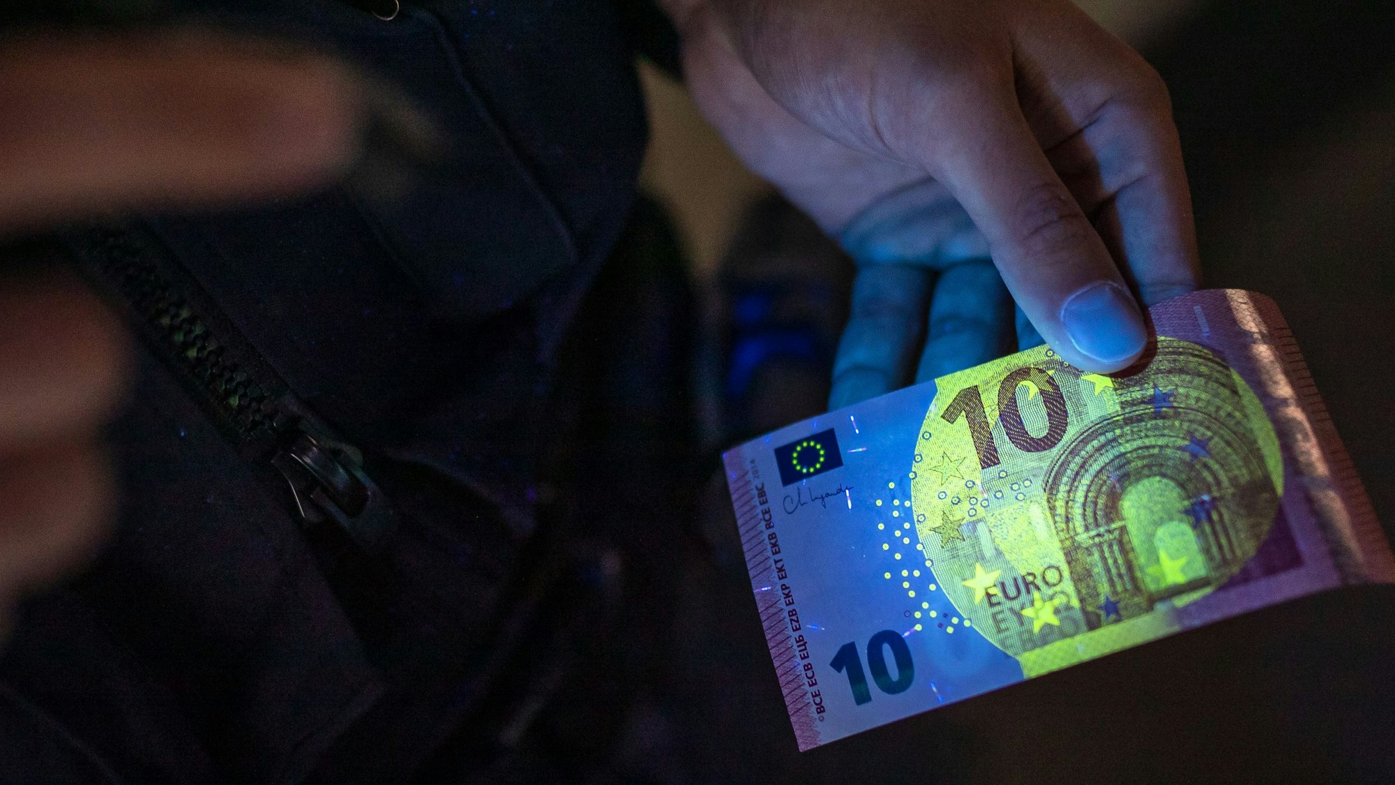 Das Bild zeigt einen 10-Euro-Schein und UV-Licht.