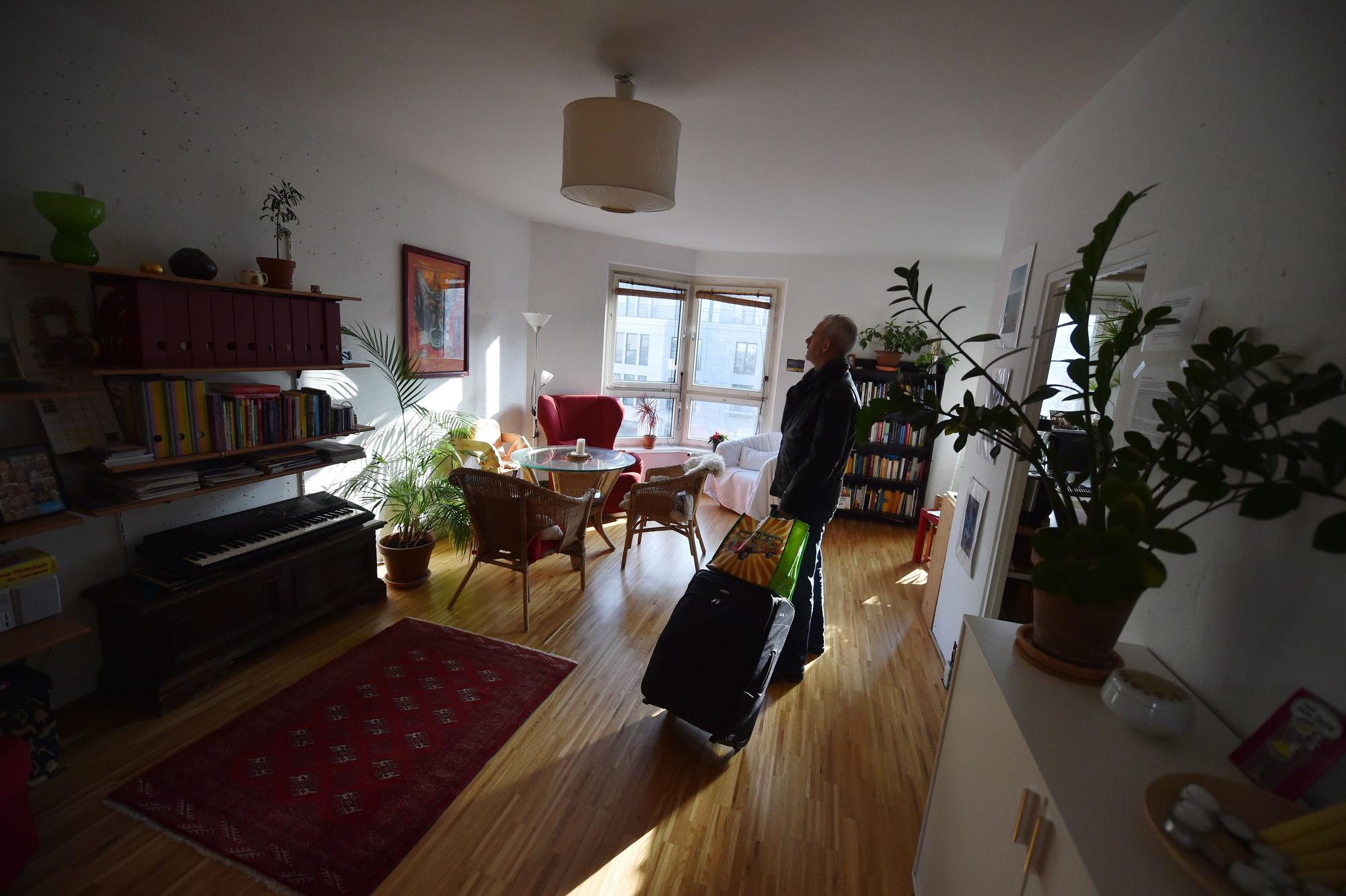 Ein Tourist, der eine Übernachtung über das Onlineportal Airbnb gebucht hat, kommt in Berlin mit seinem Koffer in der gemieteten Wohnung an.