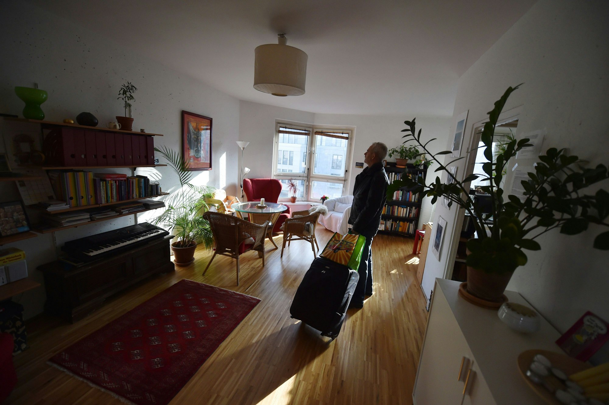 Ein Tourist, der eine Übernachtung über das Onlineportal Airbnb gebucht hat, kommt in Berlin mit seinem Koffer in der gemieteten Wohnung an.