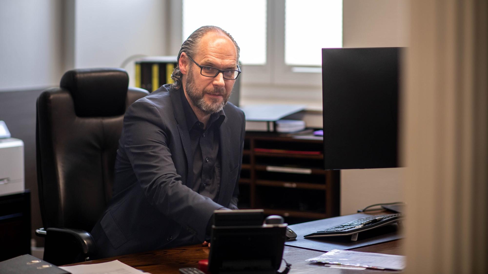 Helmut Häfner sitzt am Schreibtisch.