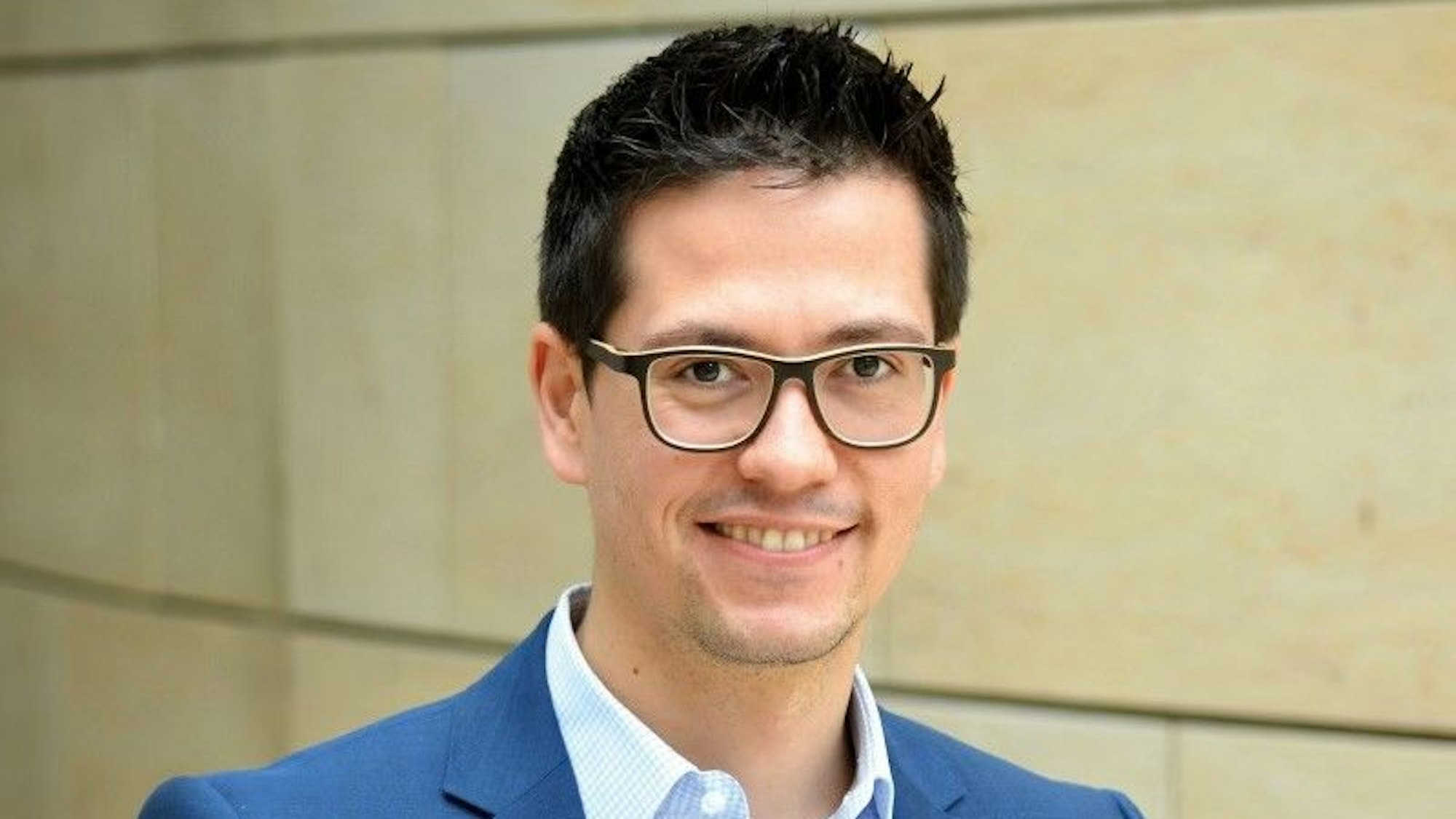 Martin-Sebastian Abel, früher Landtagsabgeordneter der Grünen in NRW, ist im Porträt zu sehen. Er lächelt in die Kamera, trägt eine schwarze Brille und kurzgeschnittene schwarze Haare.