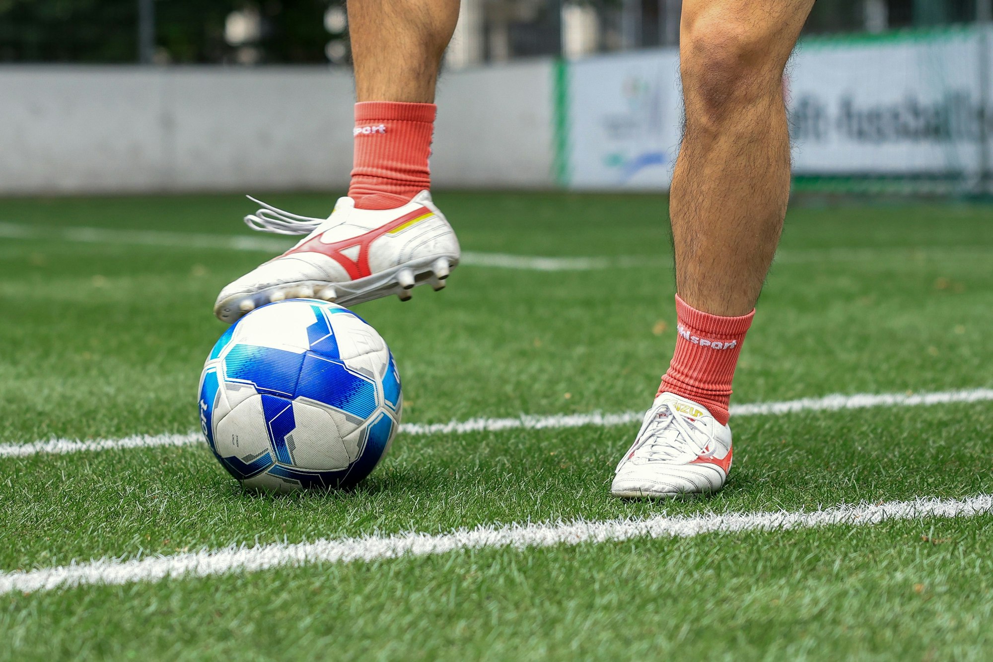 Der Fuß eines jungen Mannes steht auf dem Ball bereit zum Zurückziehen.