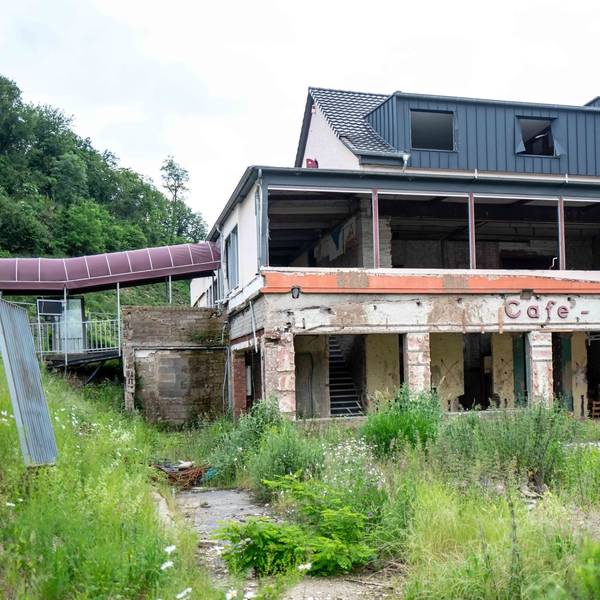 Das einstige Café Lang in Altenahr ist nach der Flutkatastrophe von 2021 noch nicht wieder aufgebaut. Das Haus steht leer, es sind keine Fenster vorhanden. Vor dem Haus wuchert Unkraut.