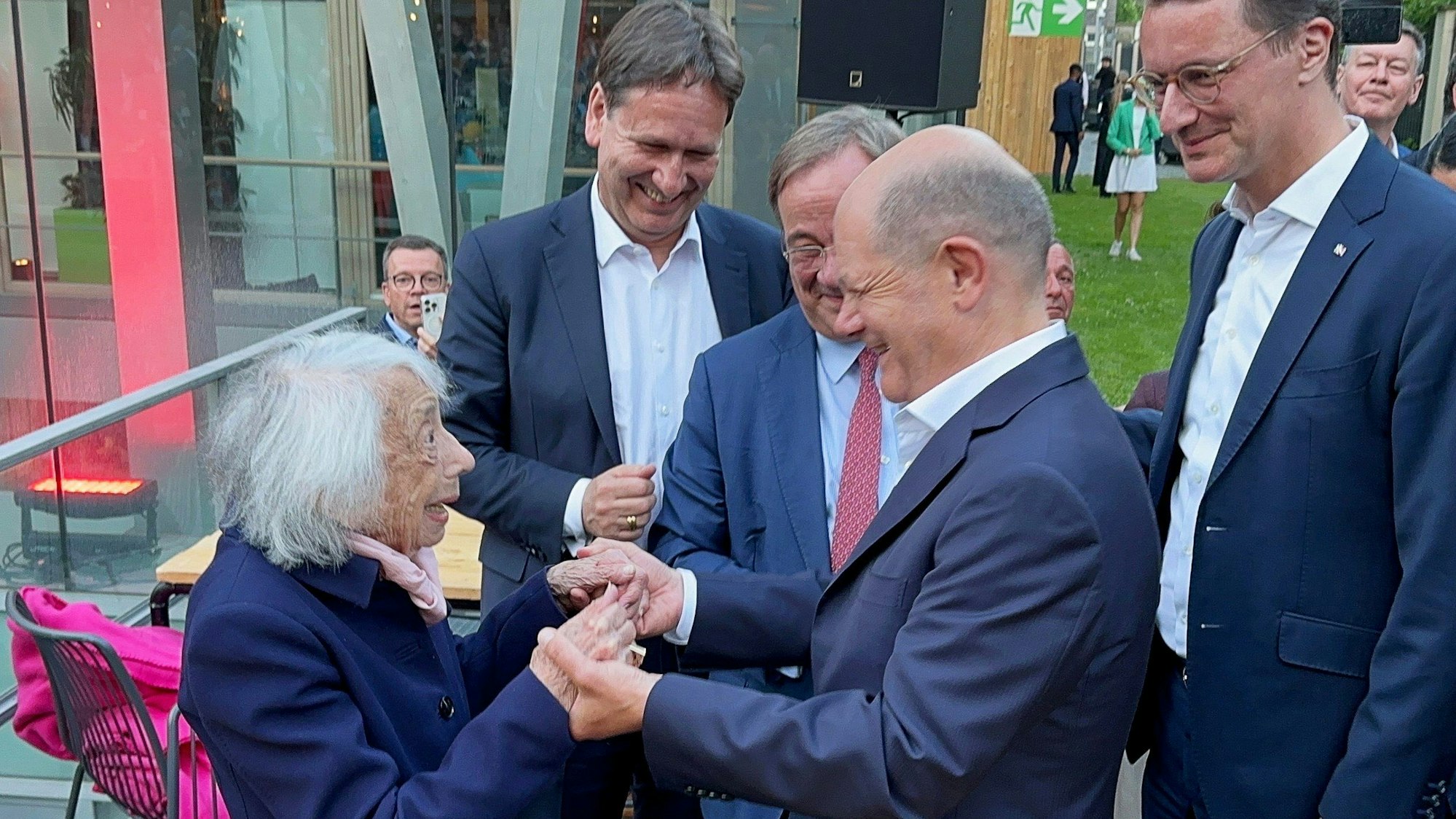 Bundeskanzler Olaf Scholz und die Holocaust-Überlebende Margot Friedländer unterhalten sich mit Armin Laschet und NRW-Ministerpräsident Hendrik Wüst beim NRW-Sommerfest in der Landesvertretung in Berlin.