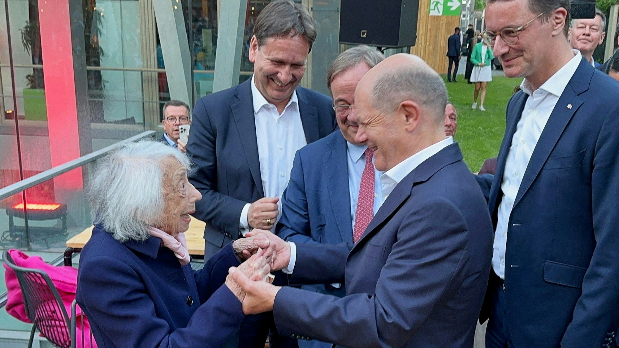 Bundeskanzler Olaf Scholz und die Holocaust-Überlebende Margot Friedländer unterhalten sich mit Armin Laschet und NRW-Ministerpräsident Hendrik Wüst beim NRW-Sommerfest in der Landesvertretung in Berlin.