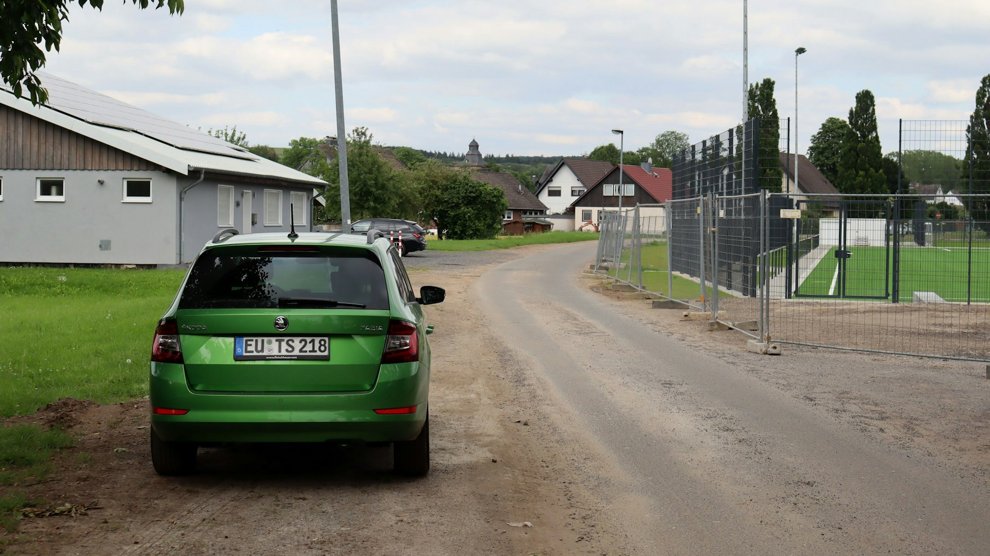 Ein Auto parkt an der Straße Im Floting, die zwischen Sportplatz und Musikheim herführt. Wenn es nach dem Willen der Politik geht, soll die Straße hinter das Musikheim verlegt werden.