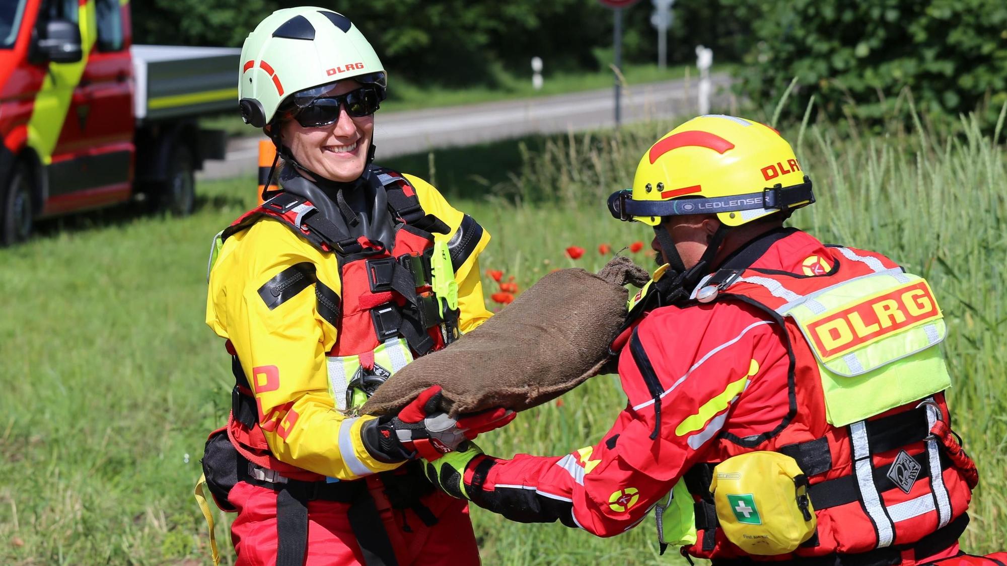 DLRG-Bezirksleiterin Jasmin Luciani nimmt einen Sandsack an.