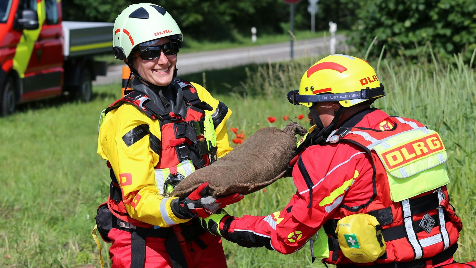 DLRG-Bezirksleiterin Jasmin Luciani nimmt einen Sandsack an.