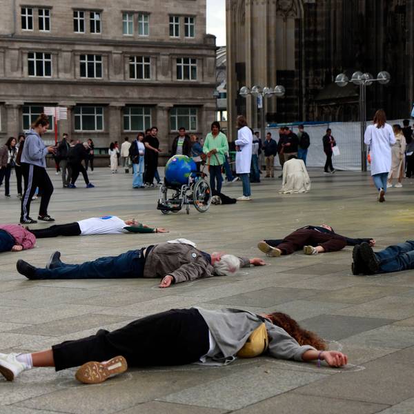 Menschen liegen vor dem Kölner Dom reglos auf dem Boden.