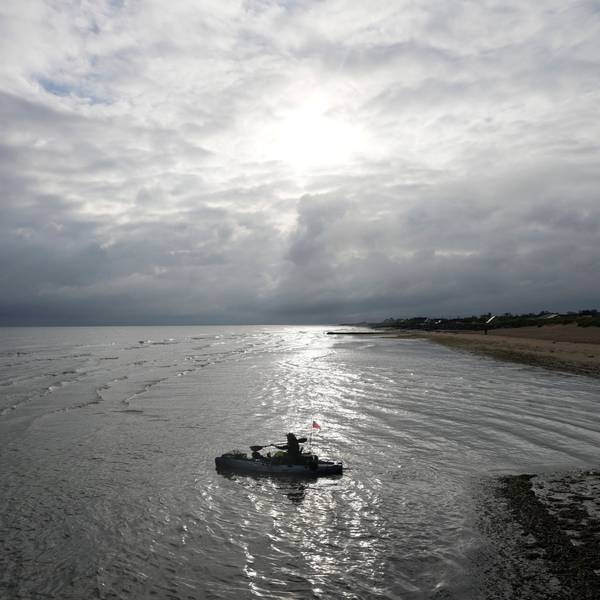 Ein Feuerwehrmann paddelt mit seinem Boot vom Gold Beach der D-Day-Invasion bei Asnelles in der Normandie hinaus.