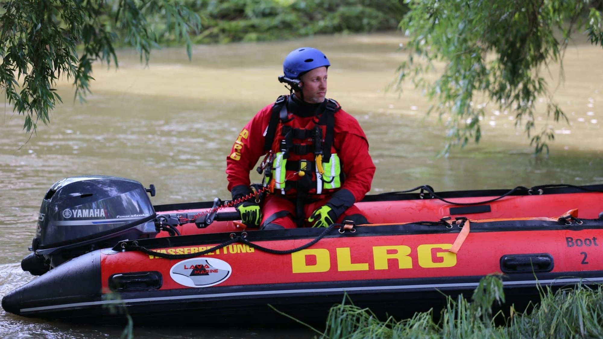 Ein DLRG-Retter fährt ein Rettungsboot im Wasser.