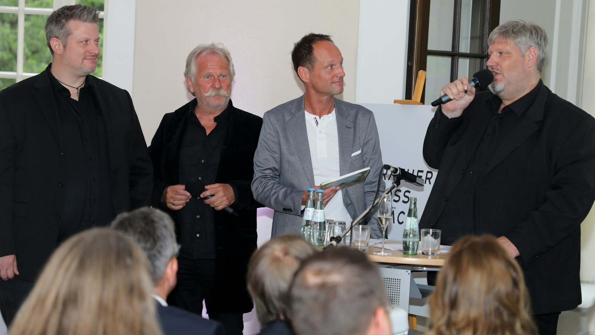 Alexander Hässy, Henning Krautmacher, Stephan Braun und Sebastian Hässy stehen im Rösrather Schloss Eulenbroich und stellen ein Projekt vor.