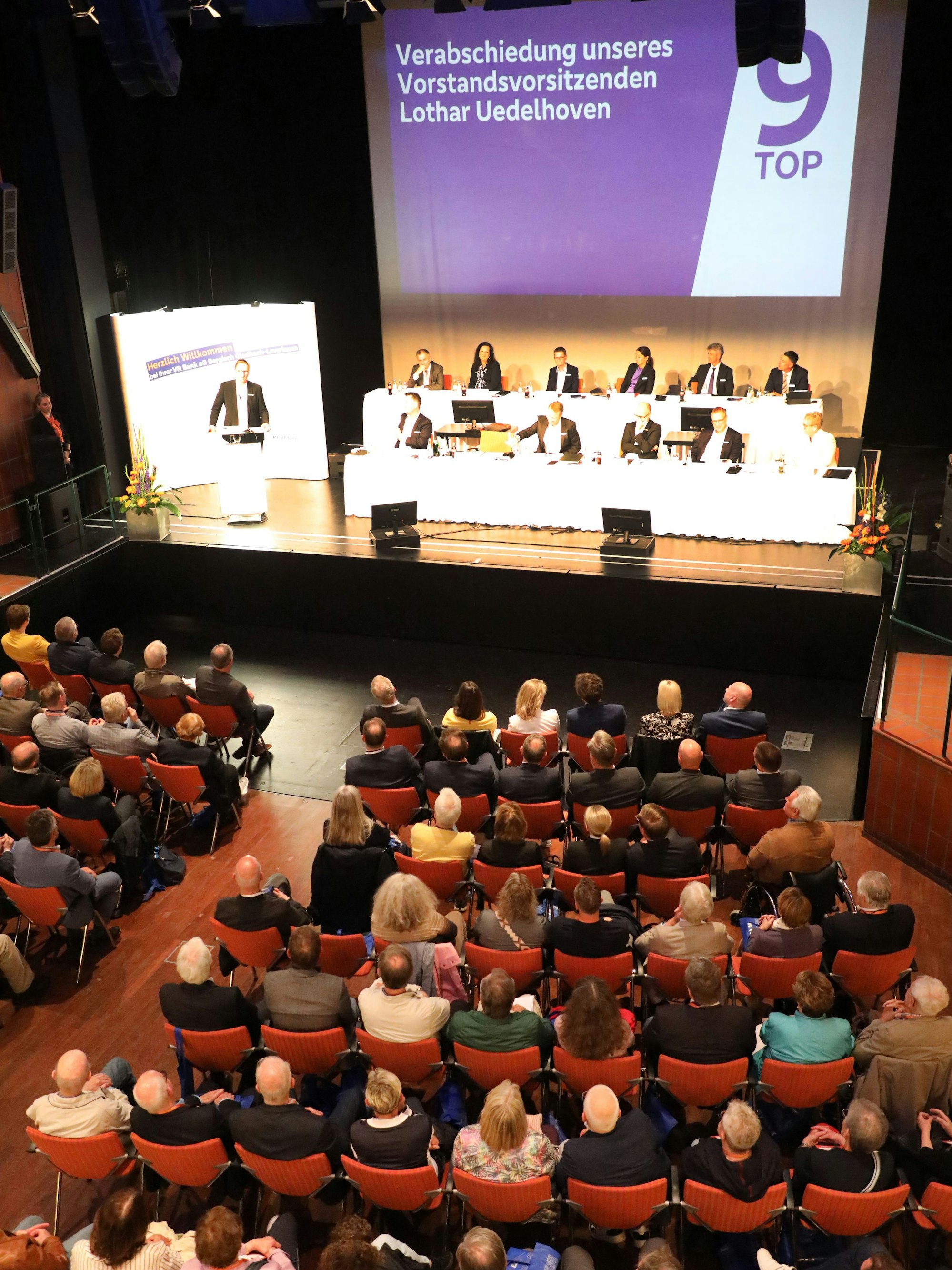 Vertreter der VR Bank sitzen im großen Saal des Bürgerhauses Bergischer Löwe.