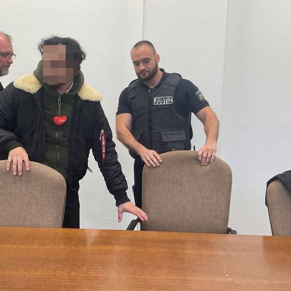 Der Angeklagte mit seinem Verteidiger Jörg Hardies und einem Wachtmeister beim Prozessauftakt im Kölner Landgericht
