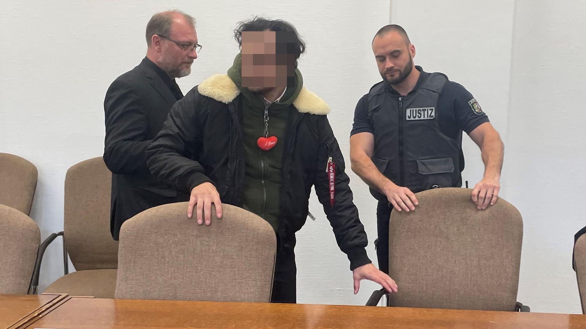 Der Angeklagte mit seinem Verteidiger Jörg Hardies und einem Wachtmeister beim Prozessauftakt im Kölner Landgericht