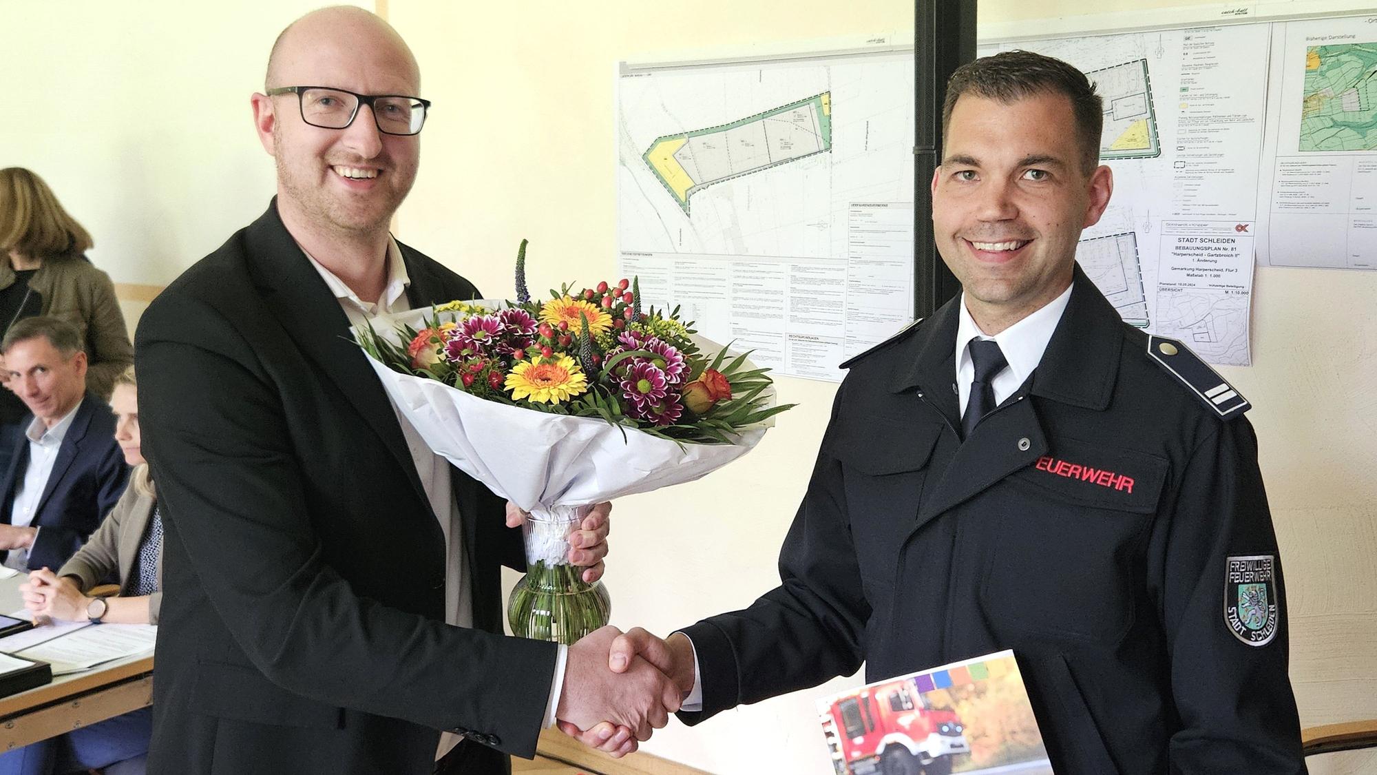Ingo Pfennings (l.) überreicht Sebastian Hörnchen einen Strauß Blumen.