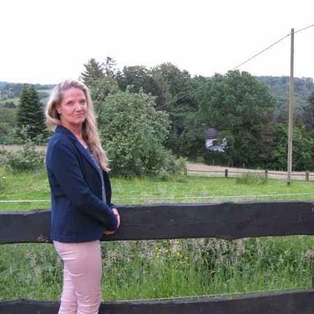 Eine Frau steht vor einem Feld.