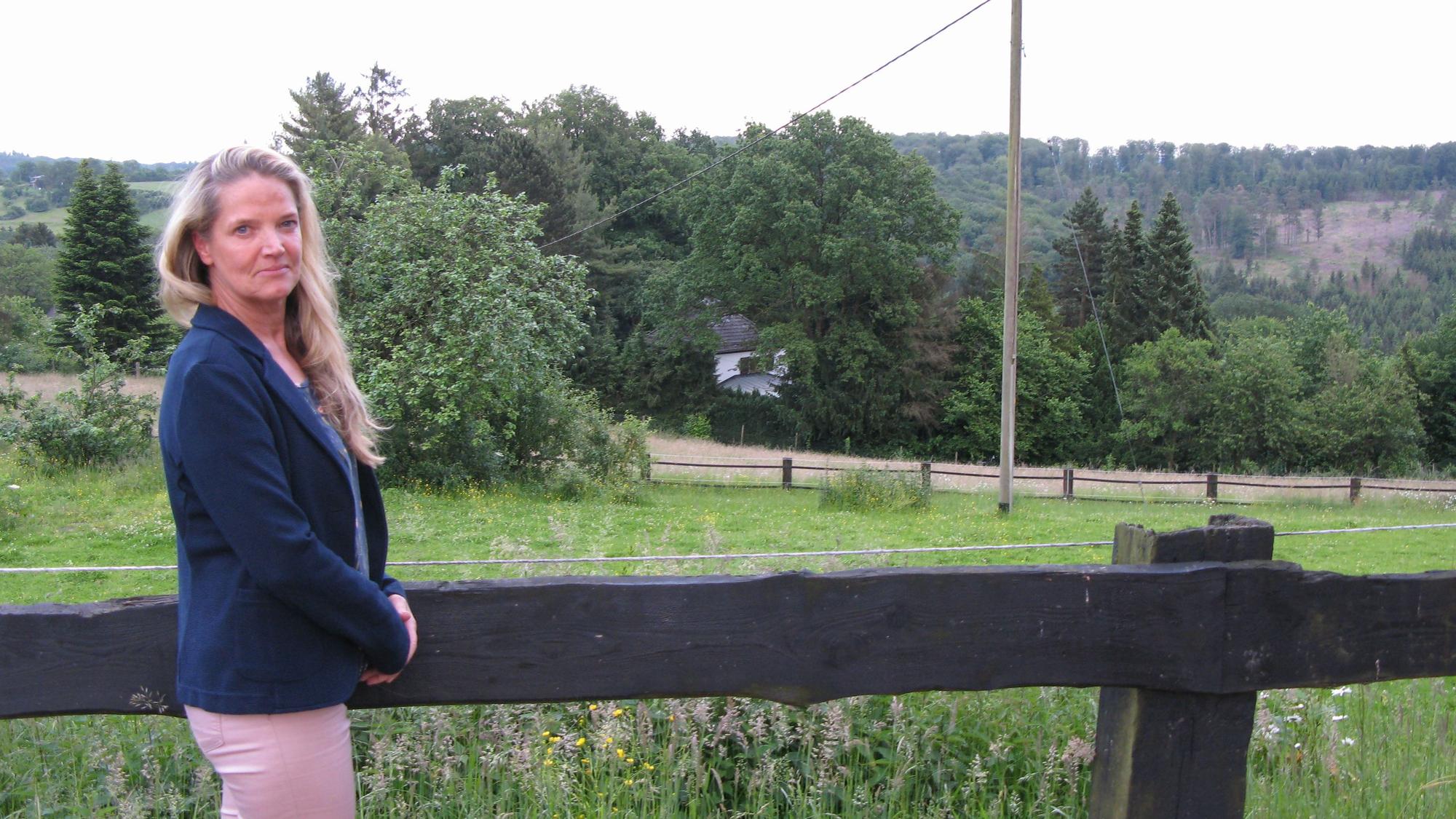 Eine Frau steht vor einem Feld.