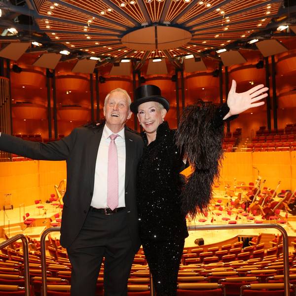 Zwei Männer stehen in der Philharmonie mit der Bühne im Rücken.