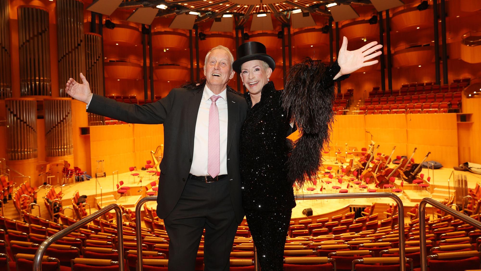 Zwei Männer stehen in der Philharmonie mit der Bühne im Rücken.