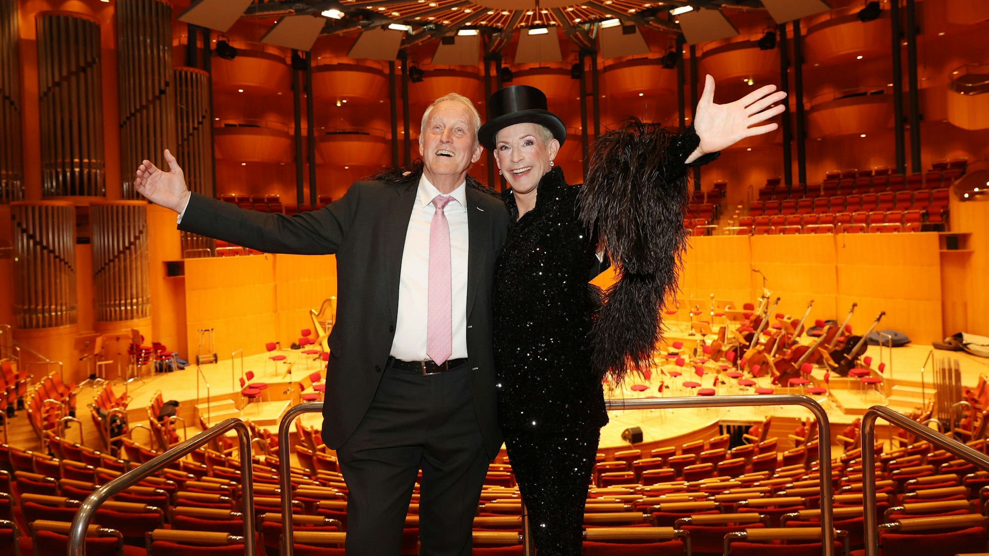 Zwei Männer stehen in der Philharmonie mit der Bühne im Rücken.