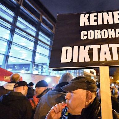 „Keine Corona Diktatur“ steht auf dem Plakat, das ein Mann bei einer Demonstration im Jahr 2022 vor dem Thüringer Landtag in den Händen hält. In Thüringen hatte das Kabinett am Vortag beschlossen, in vielen Bereichen des öffentlichen Lebens eine 2G-Pflicht einzuführen. 2G bedeutet, dass dort nur noch geimpfte oder von einer Covid-19-Erkrankung genesene Menschen Zutritt haben. +++ dpa-Bildfunk +++