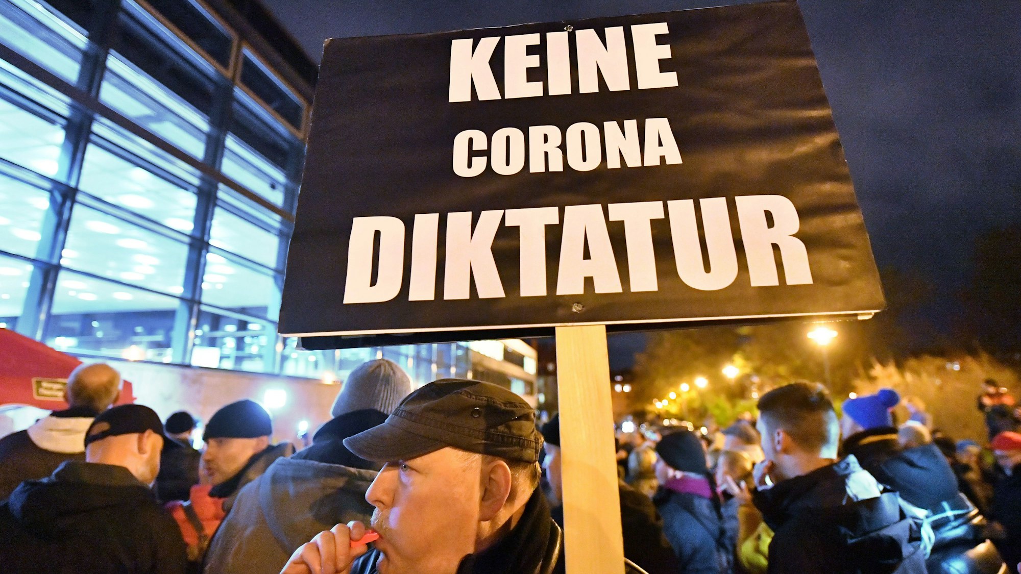 „Keine Corona Diktatur“ steht auf dem Plakat, das ein Mann bei einer Demonstration im Jahr 2022 vor dem Thüringer Landtag in den Händen hält. In Thüringen hatte das Kabinett am Vortag beschlossen, in vielen Bereichen des öffentlichen Lebens eine 2G-Pflicht einzuführen. 2G bedeutet, dass dort nur noch geimpfte oder von einer Covid-19-Erkrankung genesene Menschen Zutritt haben. +++ dpa-Bildfunk +++