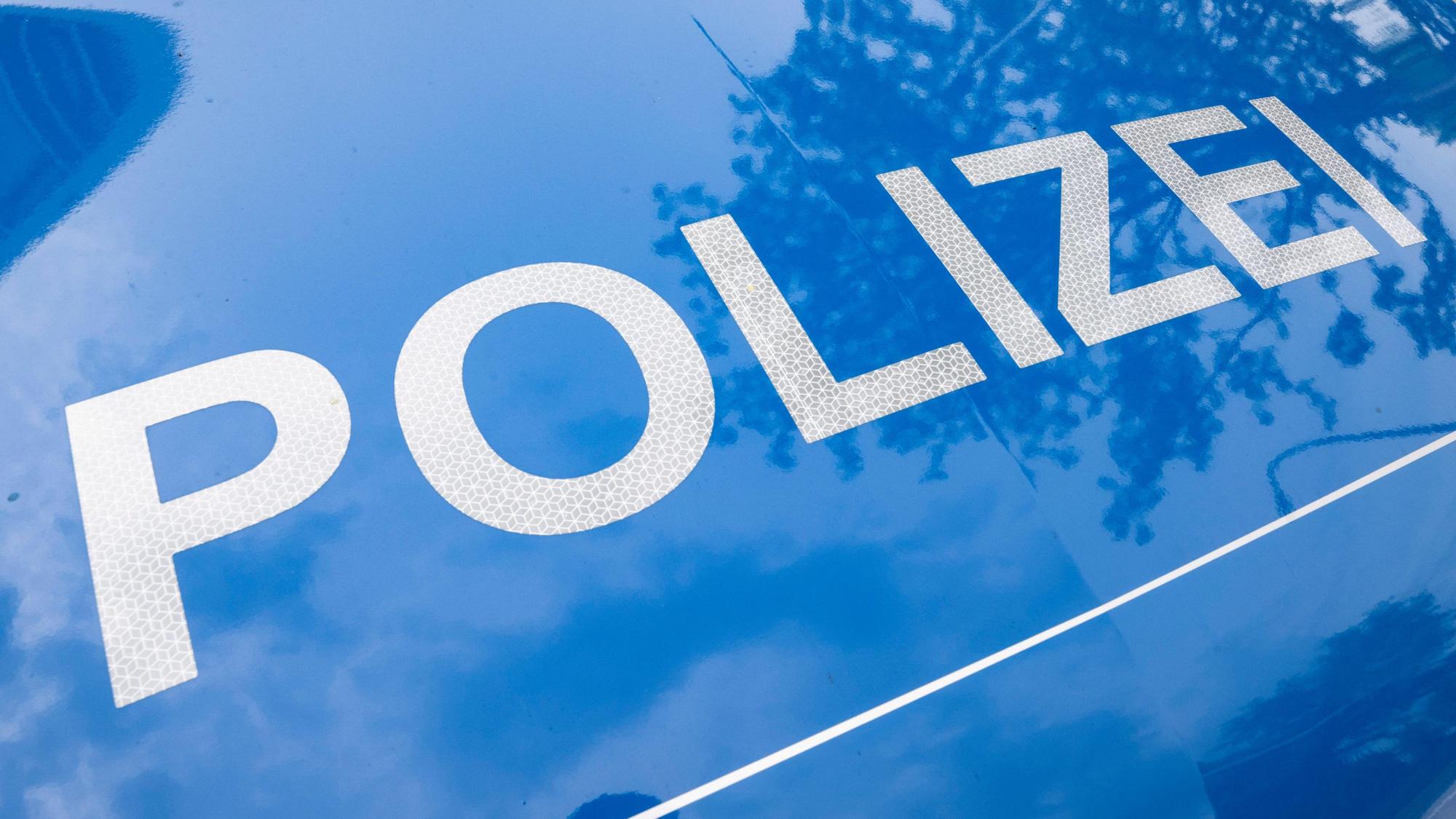 Der Schriftzug ·Polizei· ist auf einem Streifenwagen zu lesen.