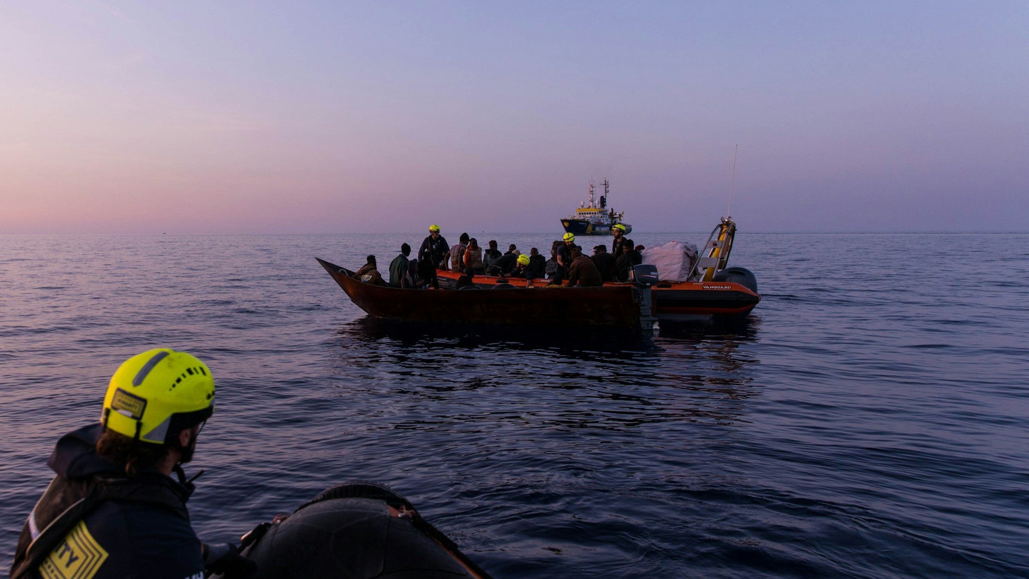 Mai 2024: Migranten auf einem Boot und Seenotretter im Mittelmeer. Seenotretter haben im Mittelmeer nahe der italienischen Insel Lampedusa ein totes Baby geborgen. Es befand sich an Bord des Eisenbootes, auf dem mehr als 40 Menschen unterwegs waren.