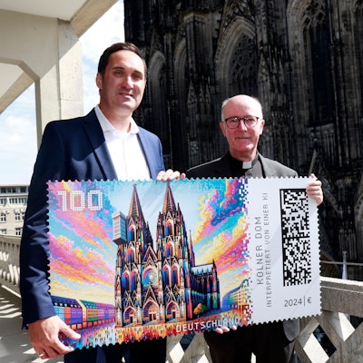 Dompropst Guido Assmannund Alexander Plum Vizepräsident im Produktmanagement „Privatkunden Brief“ bei der Vorstellung der KI generierten Briefmarke mit dem Kölner Dom.