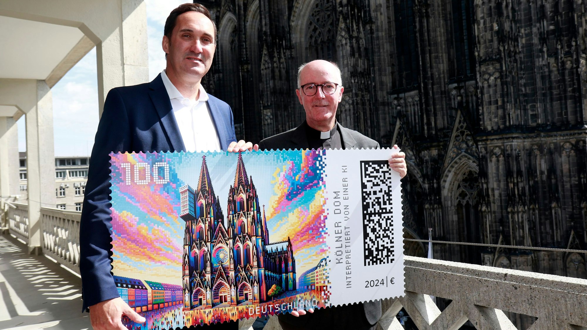 Dompropst Guido Assmannund Alexander Plum Vizepräsident im Produktmanagement „Privatkunden Brief“ bei der Vorstellung der KI generierten Briefmarke mit dem Kölner Dom.