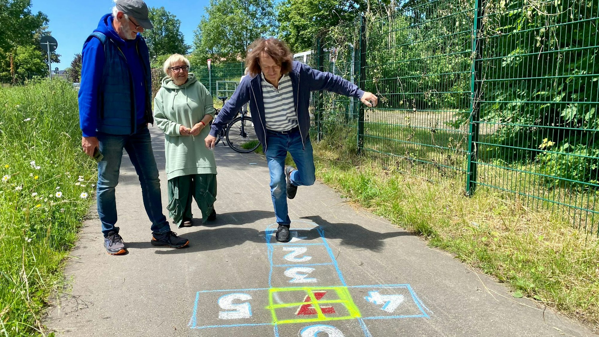 Leo Schmidt (v.l.), Anne Bergmann und Thomas Latzke spielen Hüpfkästchen.