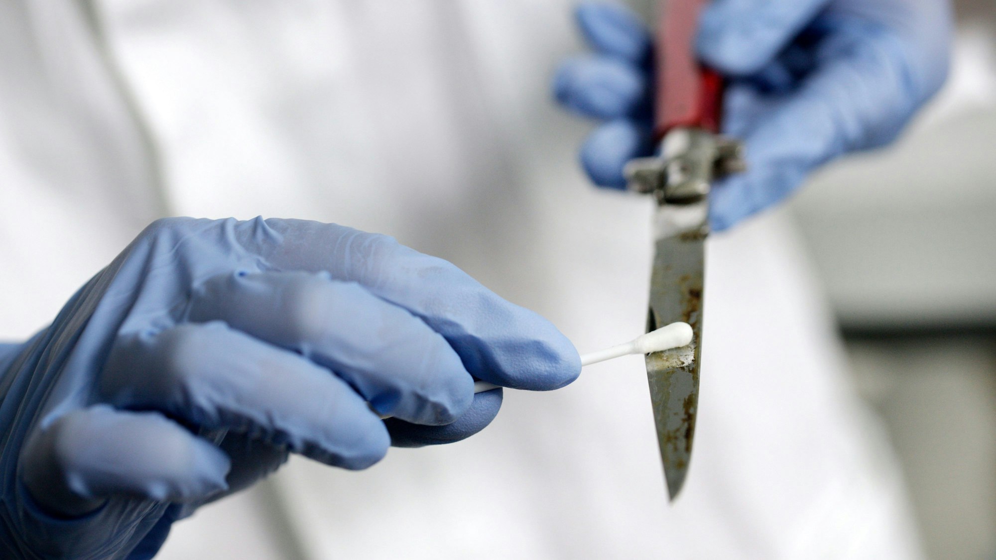 Eine Labormitarbeiterin nimmt im Amtssitz des Landeskriminalamts Nordrhein-Westfalen eine DNA-Probe von einem Messer.