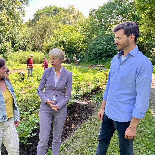 Schulministerin Feller (M.) lässt sich von Marianne Ackermann und Lars Dietrich das Naturgut Ophoven – hier den Schulgarten – zeigen.