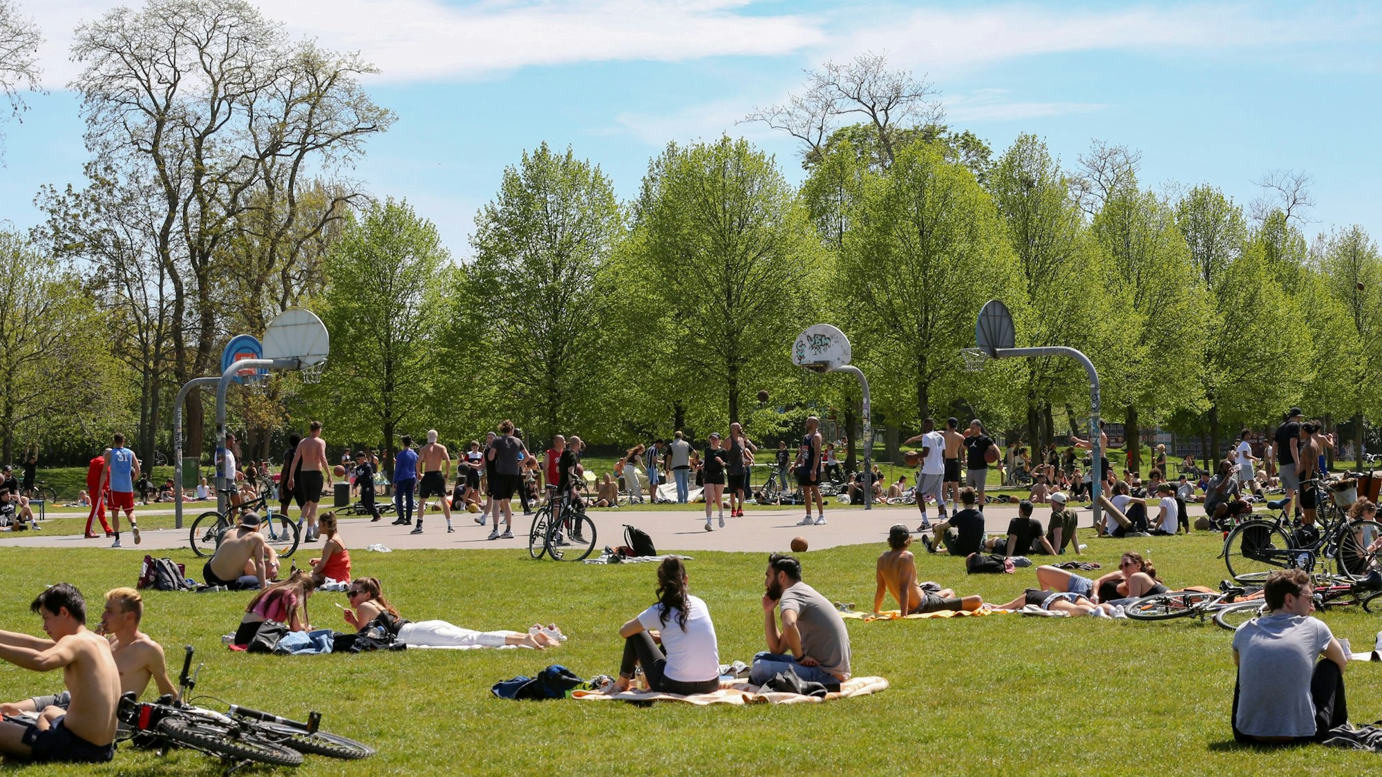 Viele Personen sitzen auf Decken auf den Wiesen im Grüngürtel.