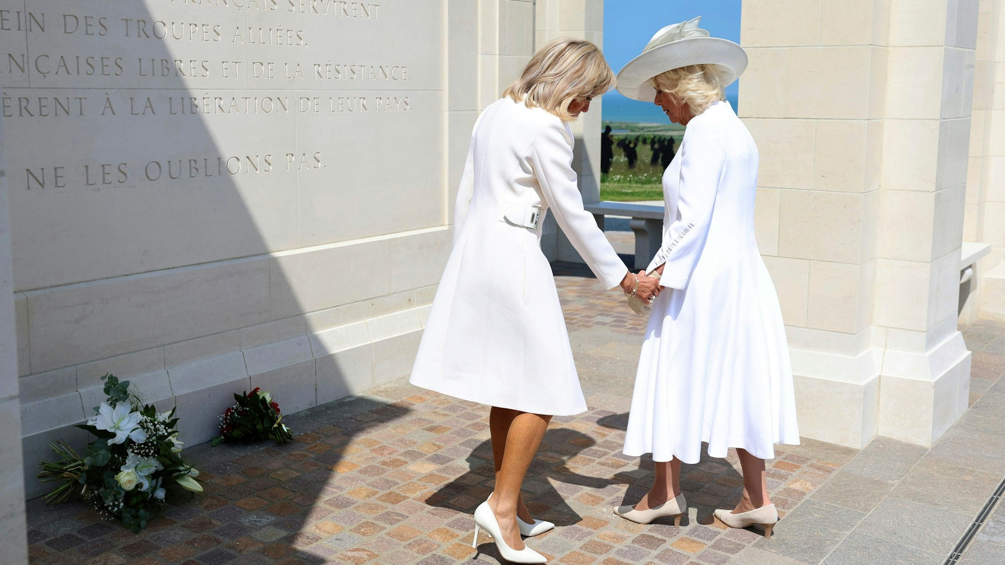 Königin Camilla und Brigitte Macron legen Blumen nieder.