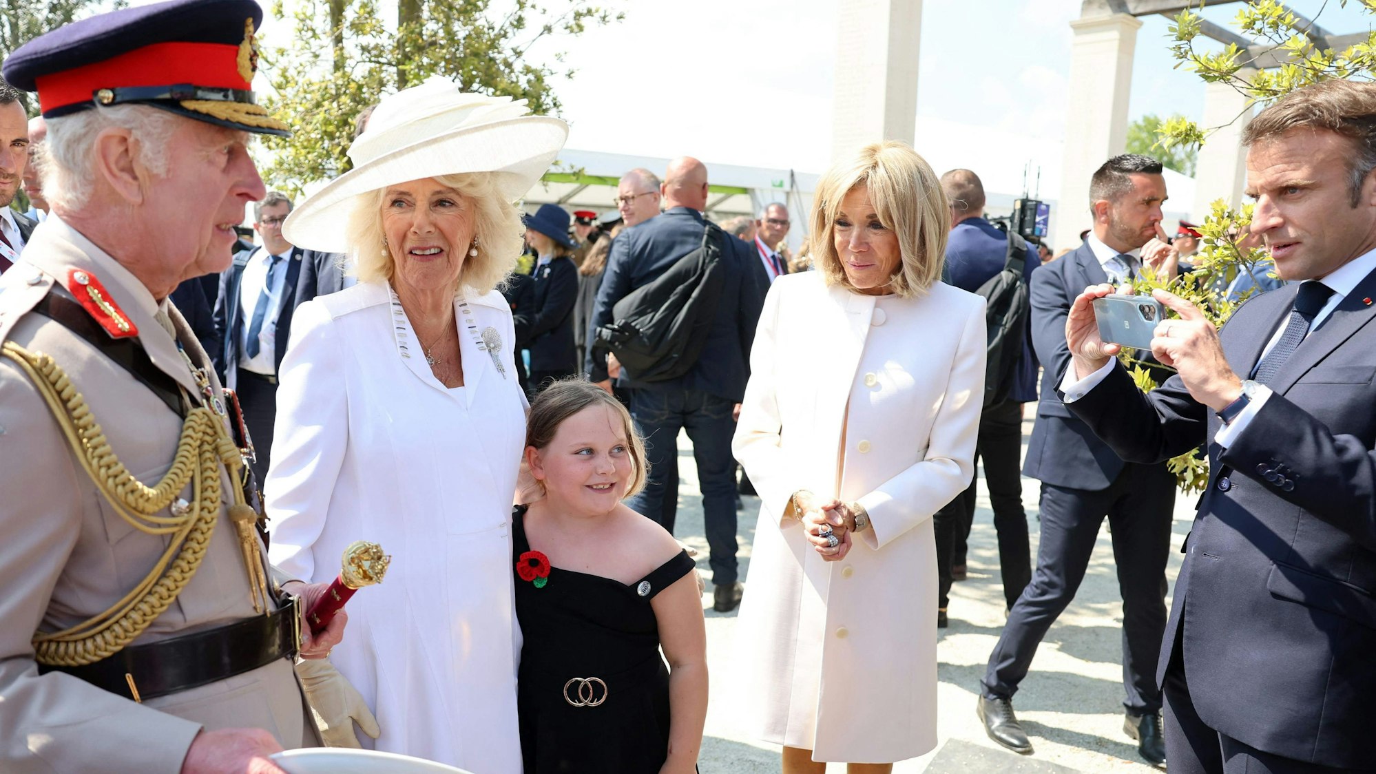 Der französische Präsident Emmanuel Macron (r) macht ein Foto mit König Charles (l) und Königin Camilla (m) während der Gedenkveranstaltung des britischen Verteidigungsministeriums und der Royal British Legion zum 80. Jahrestag der Landung der Alliierten in der Normandie.