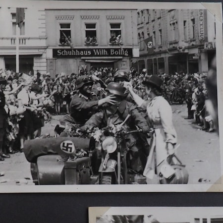 Soldaten auf einem Motorrad mit Beiwagen fahren auf den Euskirchener Marktplatz. Am Rand stehen jubelnde Menschen.