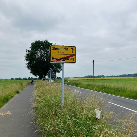 Ein Verkehrsschild weist auf den Ortsausgang von Neuboddenberg hin. Steinbüchel wird als nächster Ort ausgewiesen.