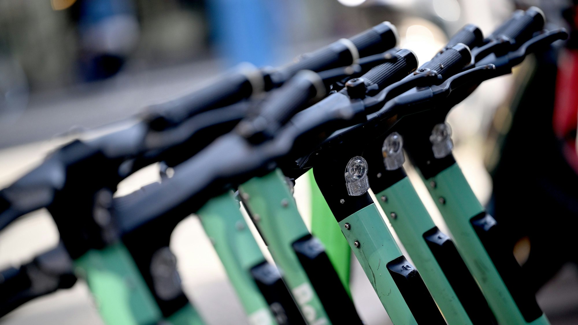 Einige E-Scooter stehen in einer Reihe an einem Stellplatz.