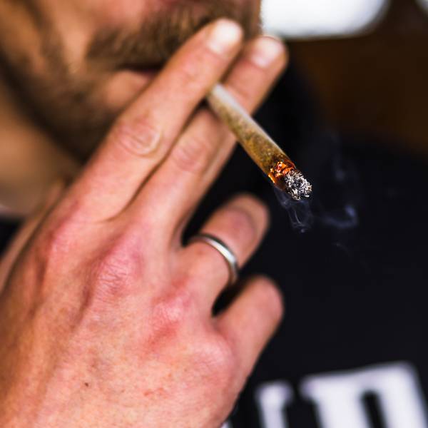 Ein Mann zieht an einem Joint.