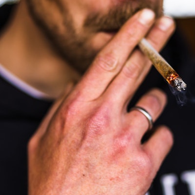 Ein Mann zieht an einem Joint.