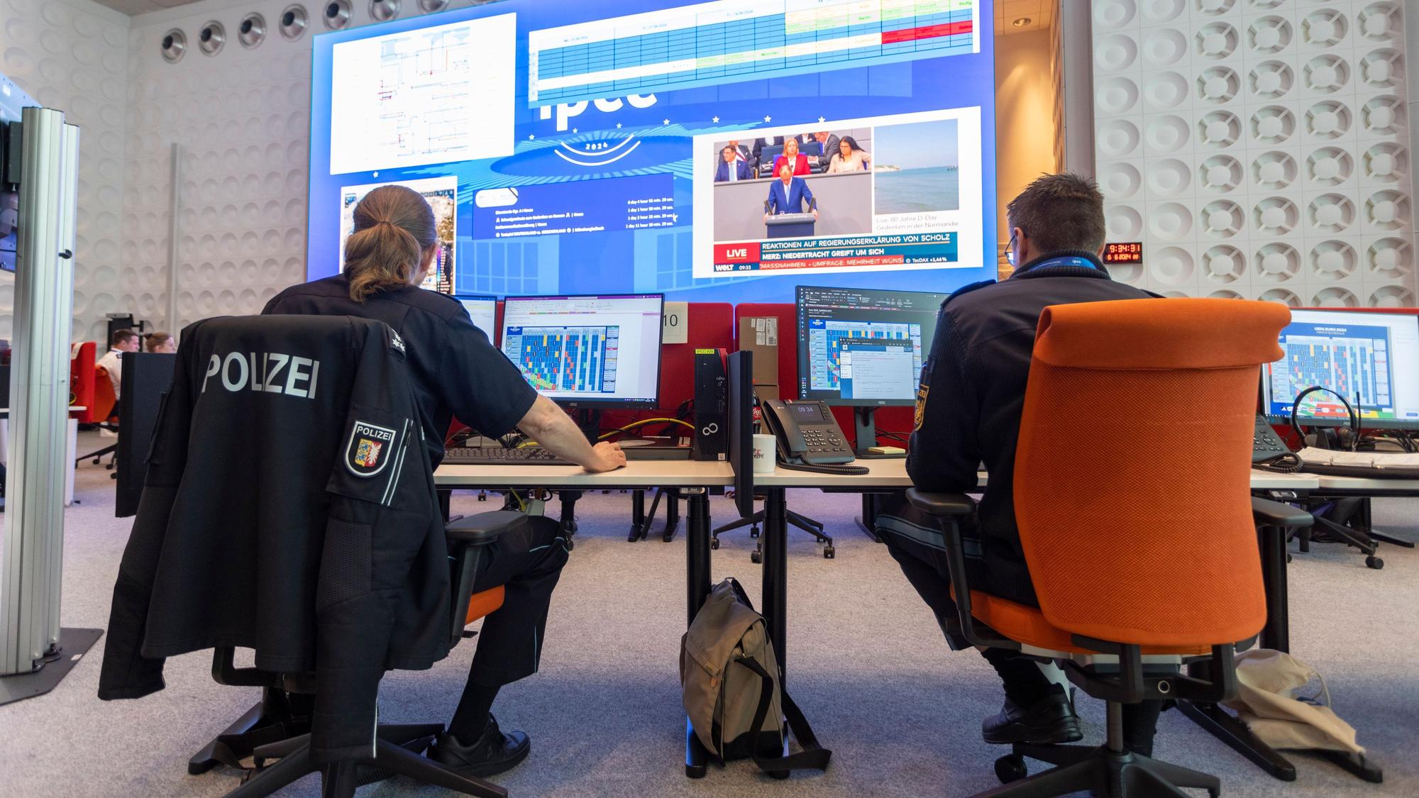 06.06.2024, Nordrhein-Westfalen, Neuss: Polizeibeamte arbeiten gemeinsam an einem Arbeitsplatz im International Police Cooperation Center (IPCC) zur UEFA EURO 2024. Foto: Thomas Banneyer/dpa +++ dpa-Bildfunk +++