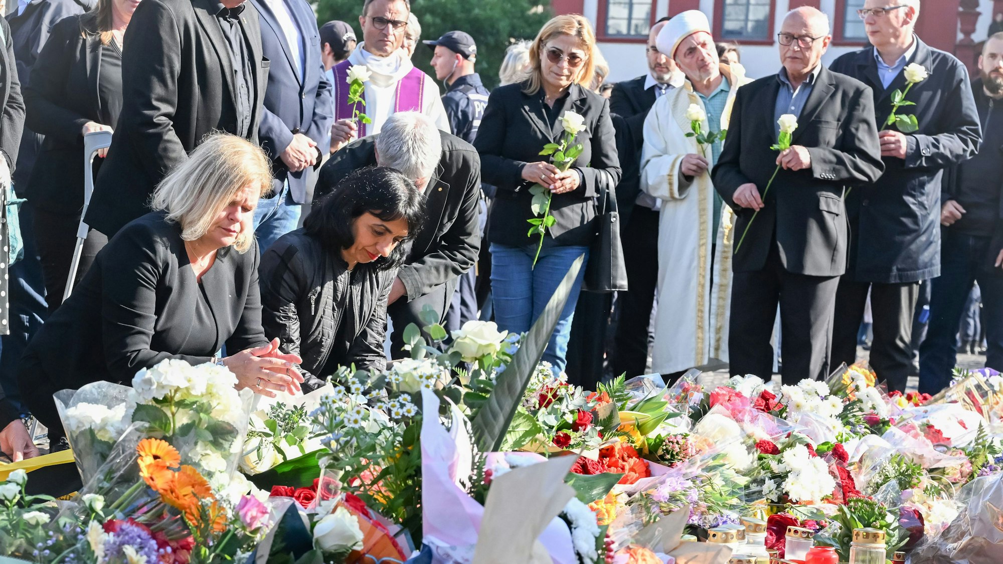 Bundesinnenministerin Nancy Faeser (l.SPD) legt zusammen mit Muhterem Aras (Bündnis 90/Die Grünen), Präsidentin des baden-württembergischen Landtags, am Marktplatz Blumen für einen bei einer Messerattacke getöteten Polizisten nieder.